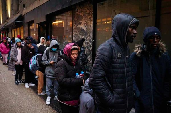 Migrants line up near an entrance to the Roosevelt Hotel  on Tuesday, December 19, 2023 in New York, N.Y. 