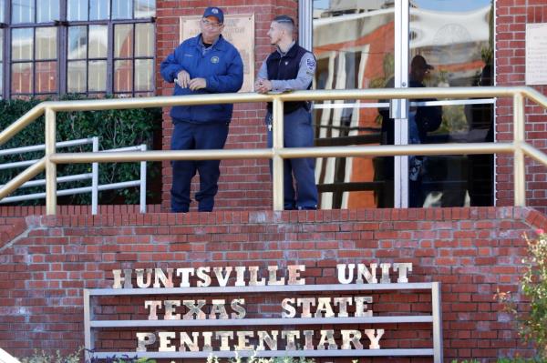 Prison staff gather outside the Huntsville Unit at the Texas State Penitentiary in Huntsville on Oct. 17, 2024.