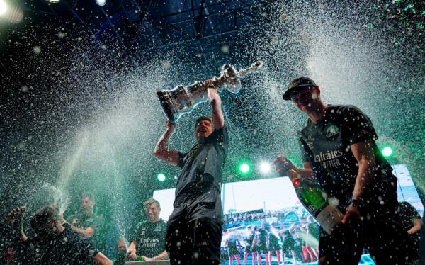 Defender Emirates Team New Zealand's co-skippers Peter Burling (L) and Nathan Outteridge (R) raise the America's Cup trophy during the trophy ceremony after winning the Louis Vuitton 37th America's Cup, in Barcelona on October 19, 2024.