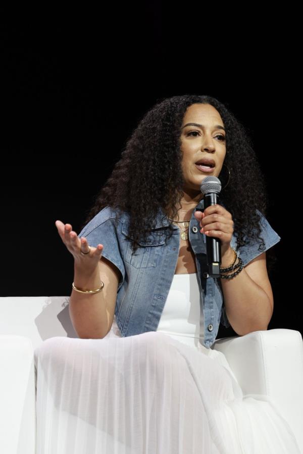 Angela Rye speaking into a microphone at the 2024 ESSENCE Festival Of Culture presented by Coca-Cola at Ernest N. Morial Co<em></em>nvention Center