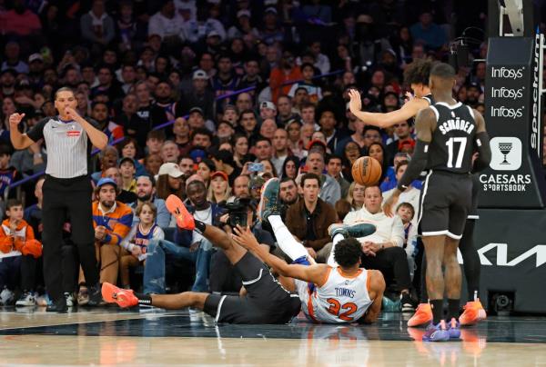 Karl-Anthony Towns #32 of the New York Knicks falls over Noah Clowney #21 of the Brooklyn Nets during the second half.