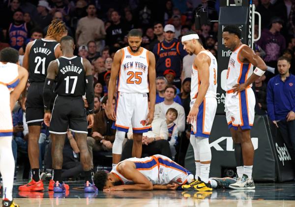 Karl-Anthony Towns #32 of the New York Knicks lays on the floor after he falls over Noah Clowney #21 of the Brooklyn Nets during the second half. 