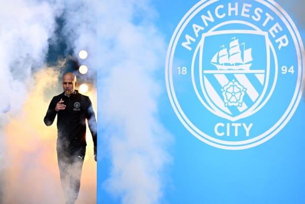 Manchester City manager Pep Guardiola smokes a cigar as he attends an event for fans with members of the Manchester City football team following an open-top bus parade through Manchester, north-west England on May 23, 2022. — AFP pic