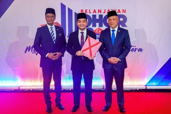 Johor Menteri Besar Datuk Onn Hafiz Ghazi (centre) with the Johor Budget 2025 book. — Bernama pic